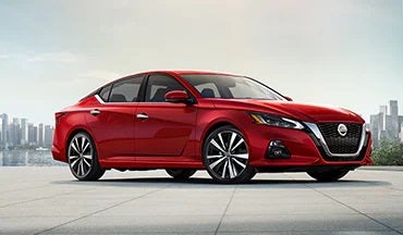 2023 Nissan Altima in red with city in background illustrating last year's 2022 model in McKinnon Nissan in Clanton AL